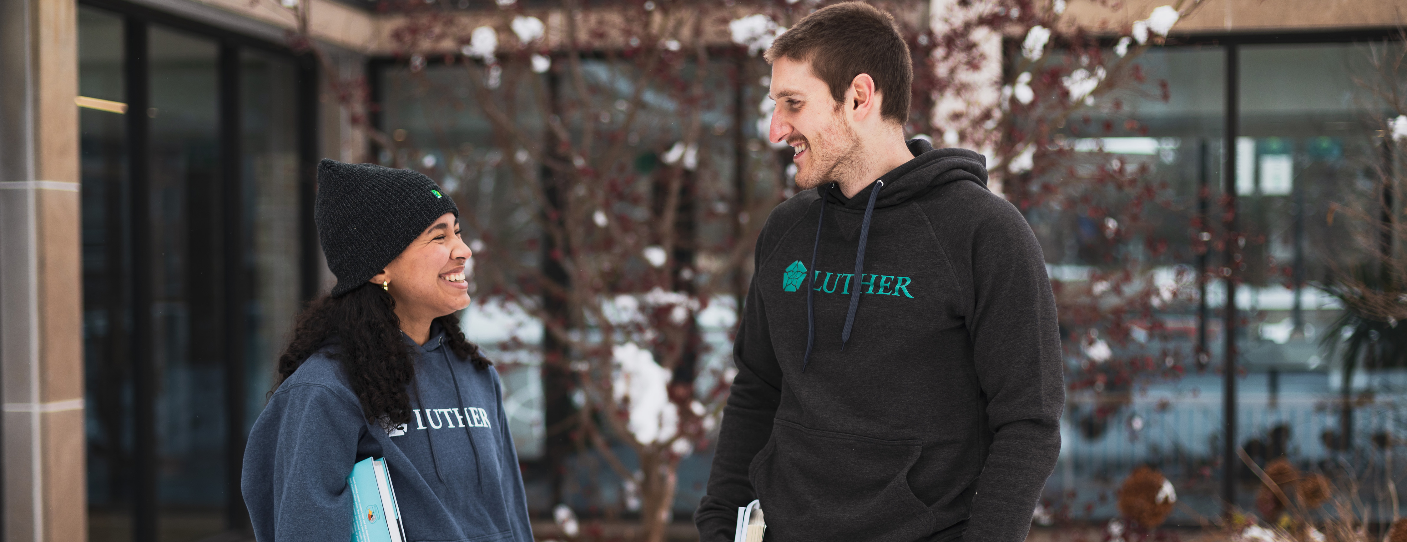 Two students standing outside in winter smiling.