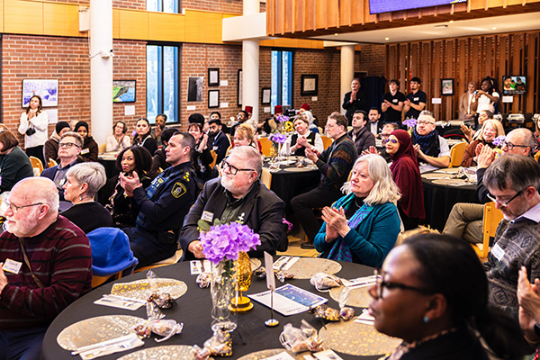 Students and community seated at cultural event in chapel space