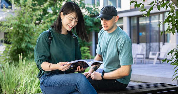 Two students reading outside