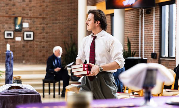 A student in a chapel holding books