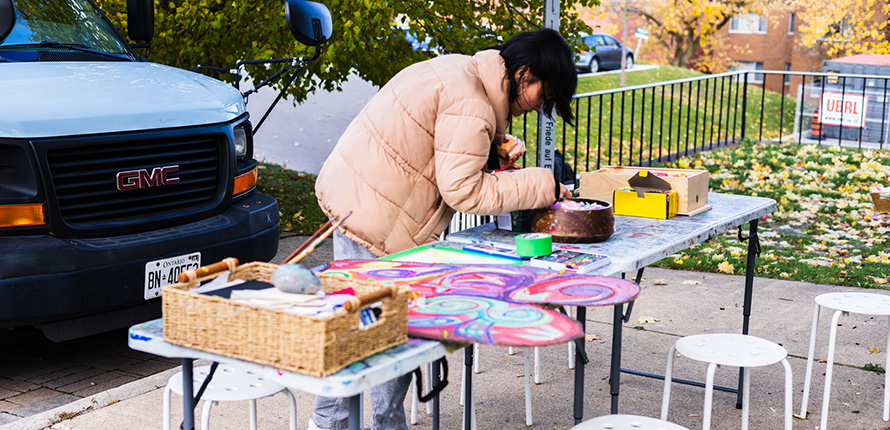 Person bent over table making art