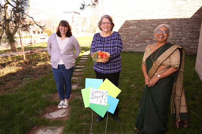 Faculty with new garden sign