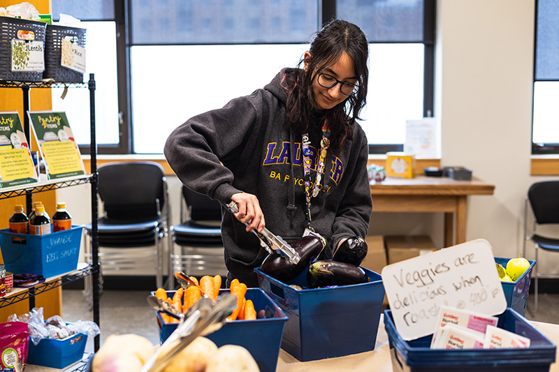 Student stocking fresh produce on table