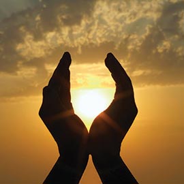 hands enclosing sun